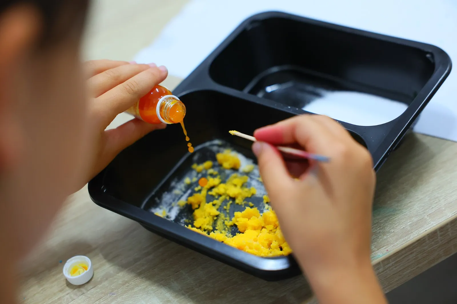 Copil care face un experiment cu pipeta și colorant