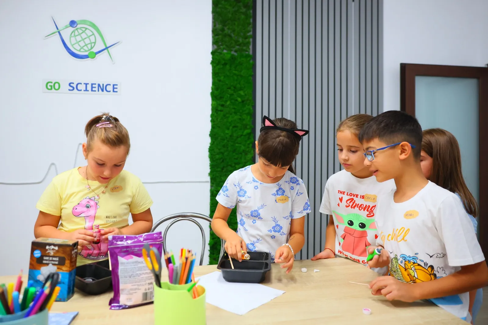 Copii care lucrează la un experiment în sala Go Science